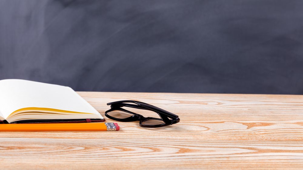 Back to school basic objects in front of erased chalkboard
