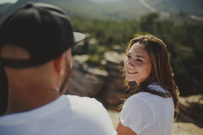 Happy couple sitting at mountain cliff