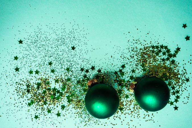 Festive xmas card concept of star glitter on baubles on green background