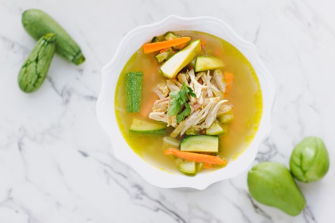 Served chicken soup with carrot and zucchini