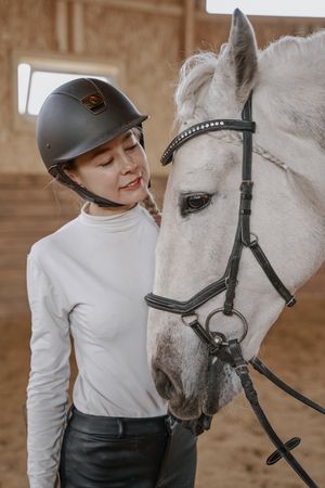 Rider with dapple gray horse in round arena