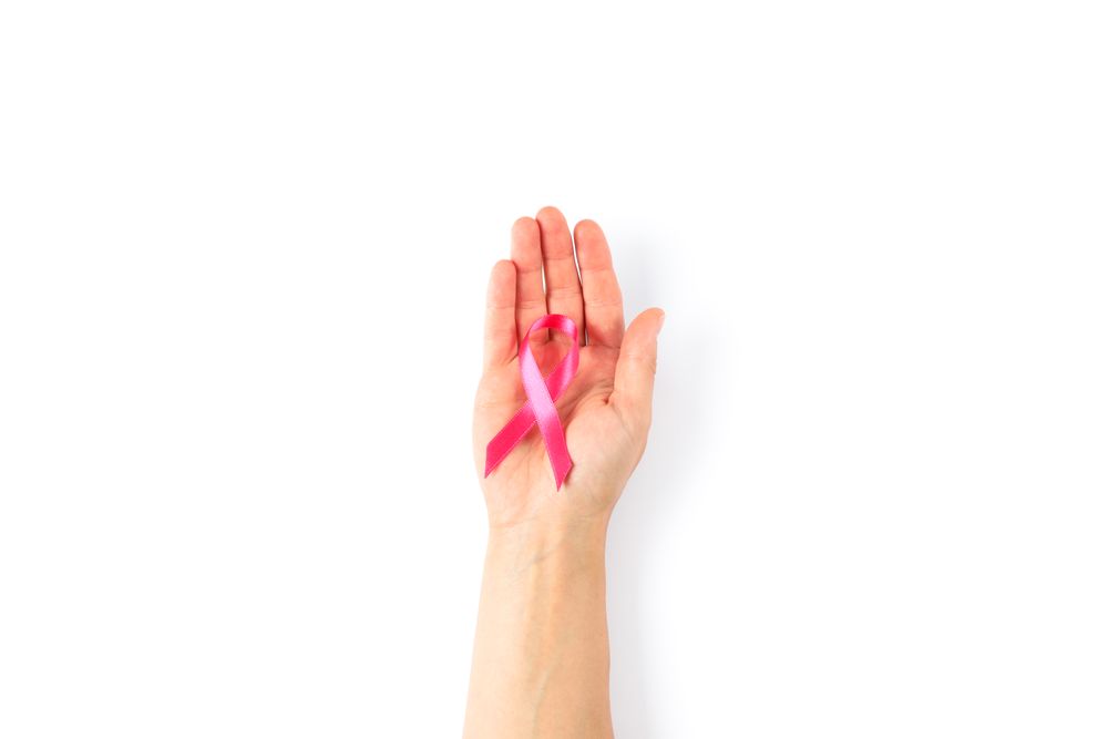 Female hand with pink awareness ribbon isolated on blank background