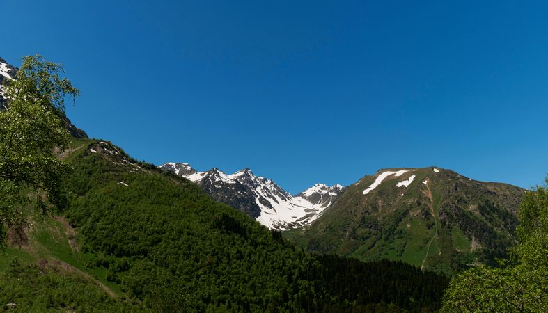 Mountain valley with snow patches and lush greenery
