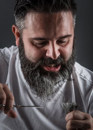 Expressive barber cutting beard