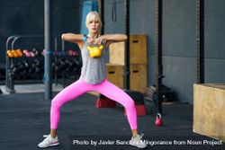 Fit woman doing full body exercise with yellow kettle bell 5ngRXD
