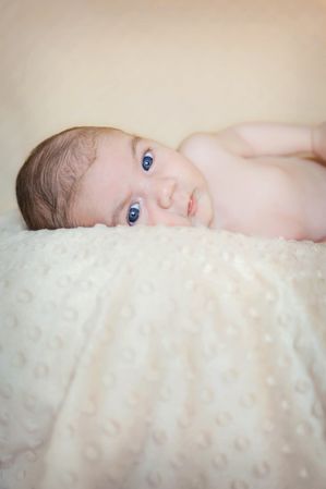 Portrait of newborn baby lying down over a blanket