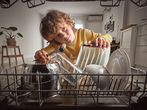 Boy with instruments checking dishwasher
