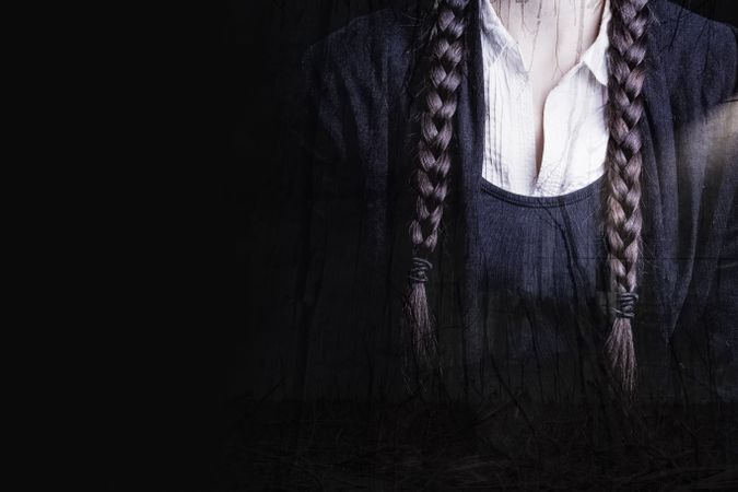Detail of braids and a white shirt of a woman with a gothic and dark look, perfect for Halloween