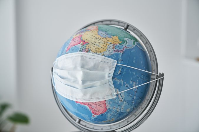Medical mask placed on globe