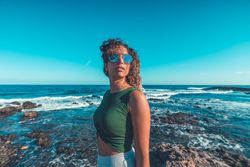 Stylish woman standing near sea