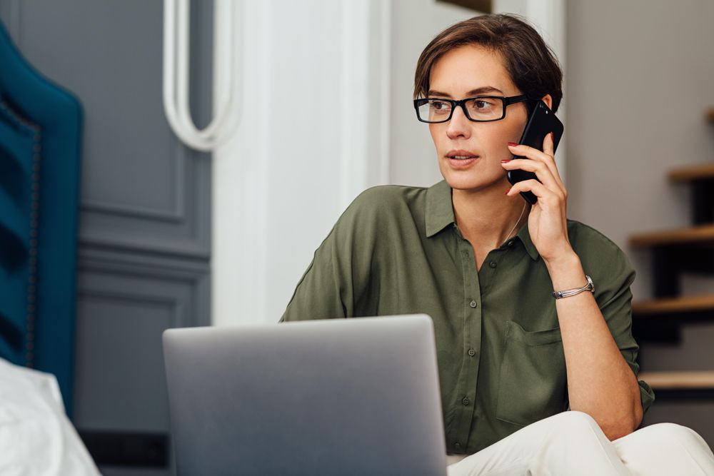 Beautiful businesswoman talking on mobile phone in her apartment