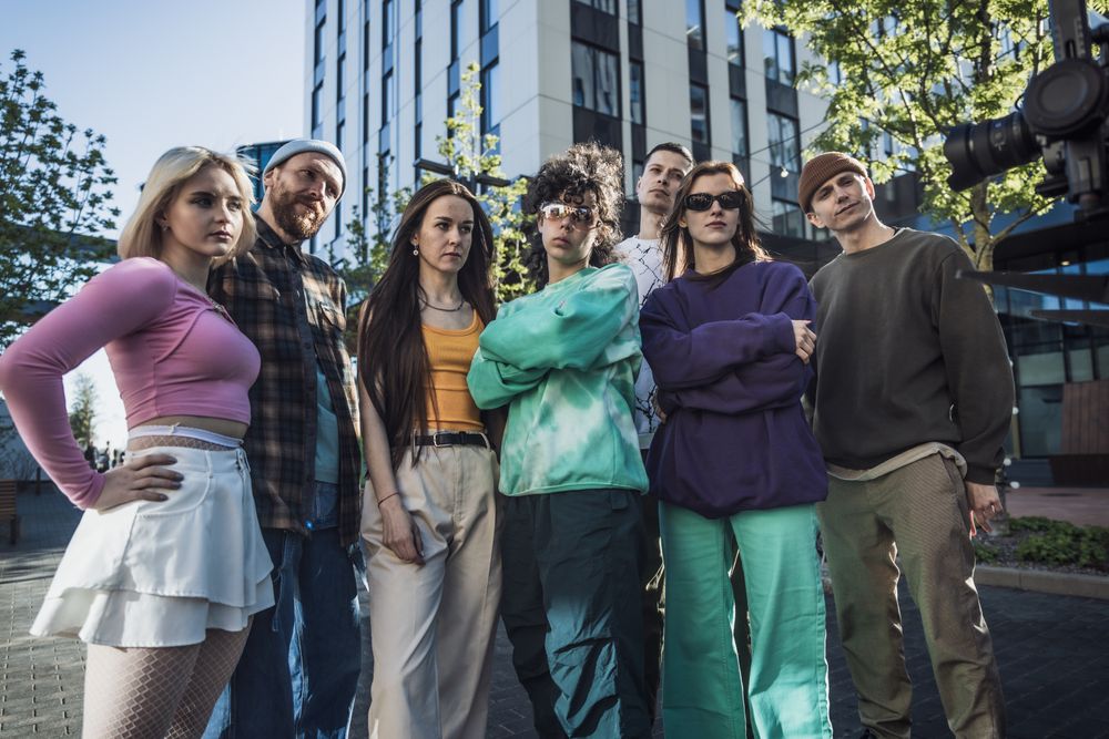 Group Of Young Adults In Eclectic Outfits Poses Confidently In An Urban Setting
