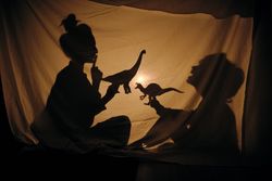 Mom and son playing with brachiosaurus in shadow theater