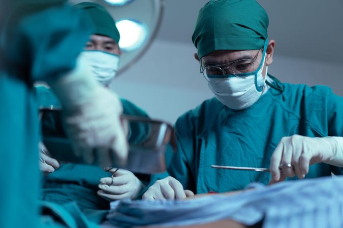 Surgeons concentrating during surgery on patient in operating theatre