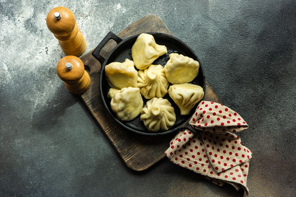 Top view of iron cast pan of traditional Georgian khinkali dumplings with copy space