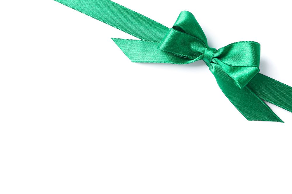Green ribbon with bow isolated on plain background. Gift concept