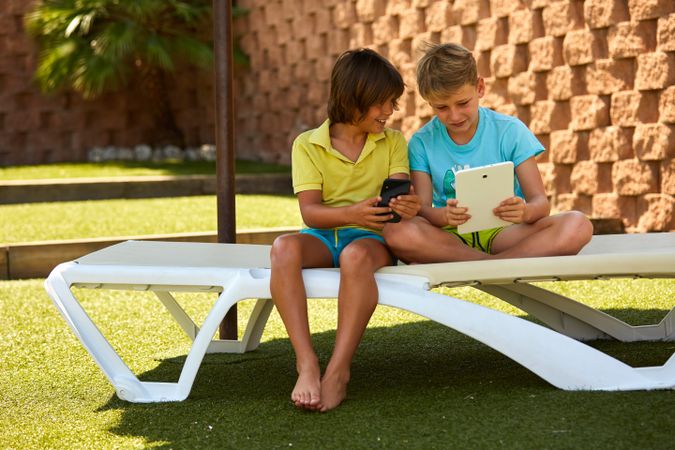 Boys using tablet in garden