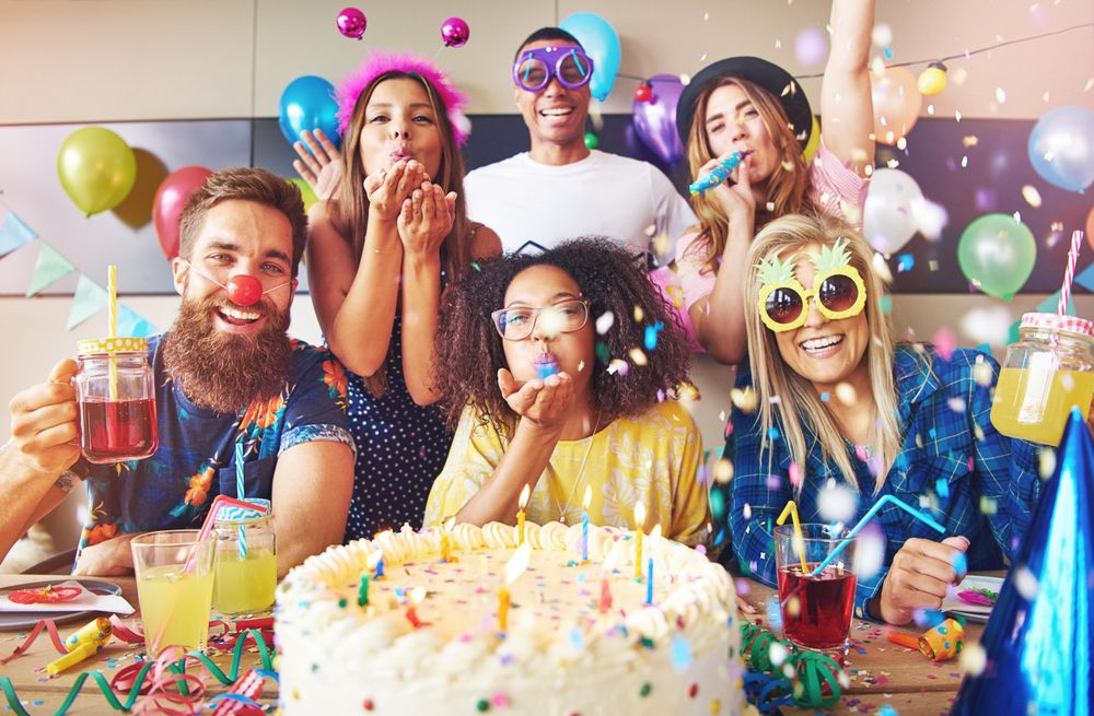 Confetti and balloons in the air as friends celebrate a birthday