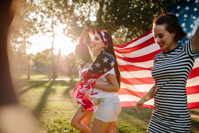 Group of woman walking with American flag in the park
