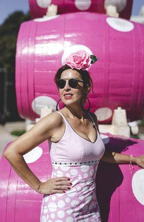 Modern woman in flamenco dress near pink barrel