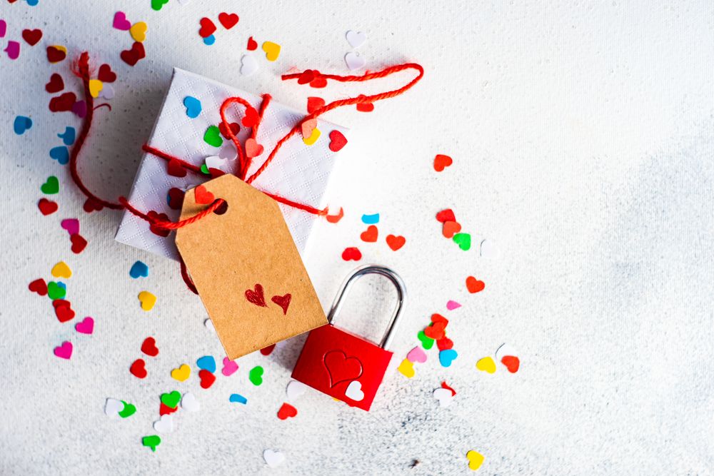 St. Valentine day concept with small gift and heart confetti and copy space