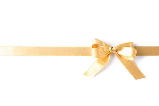 Golden ribbon with bow isolated on blank background. Gift concept