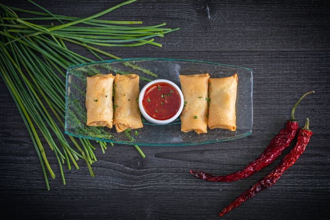 Vietnamese rolls with sweet chili on glass plate