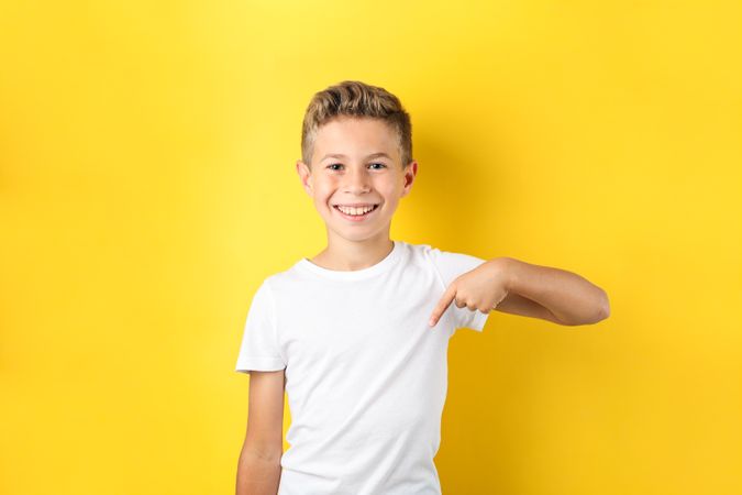 Boy in t-shirt against yellow background, space for text