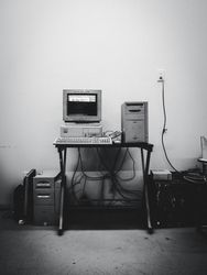 Grayscale photo of computer desktop in a room 0LJPV4