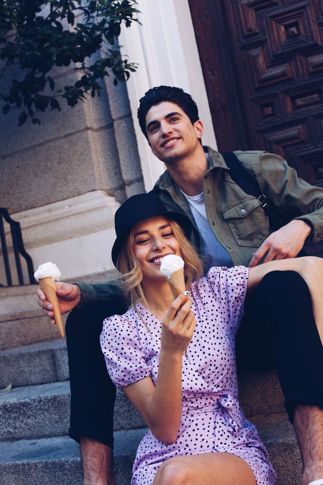 Happy couple feeding each other by ice cream