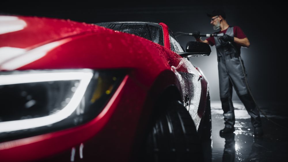 Adult Man Washing Away Dirt, Preparing an American Muscle Car for Detailing.