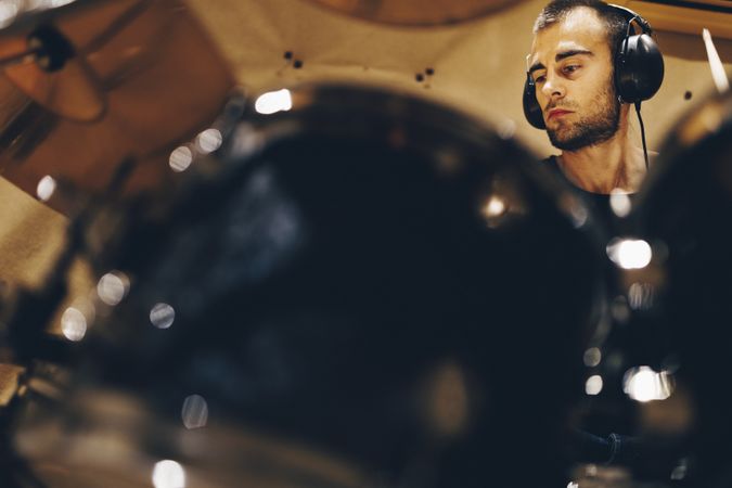 Man with headphones playing on drums