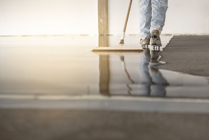 Worker working on the floor of an industrial building with special shoes to avoid damaging the floor.