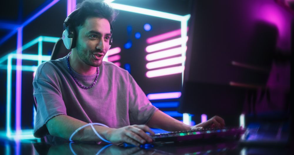 Young Excited Gamer Playing Online Video Game on a Computer.