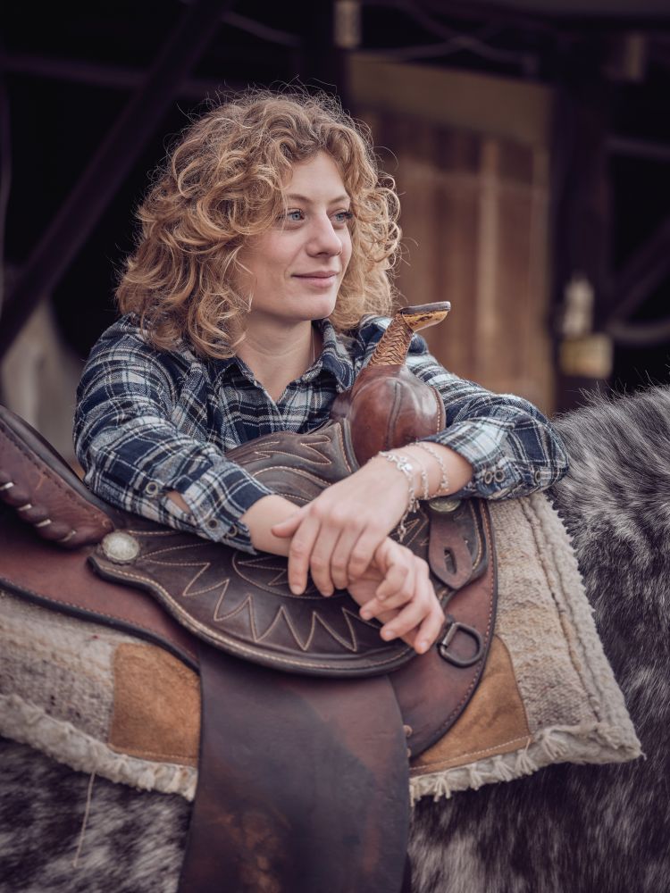 Woman near horse with saddle