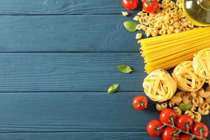 Composition with pasta ingredients on wooden background, space for text and top view
