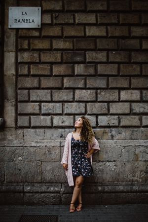 Adult woman leaning on old stone wall