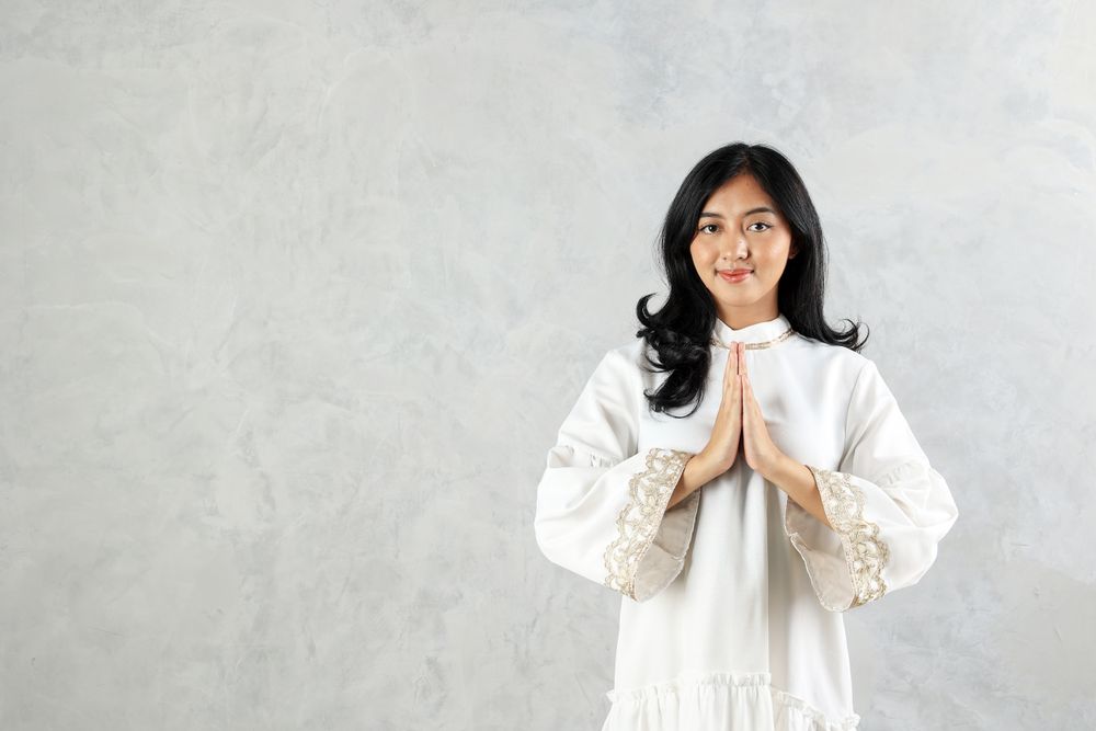 Female Asian Muslim Wearing Abaya Gesturing Eid Mubarak Greeting