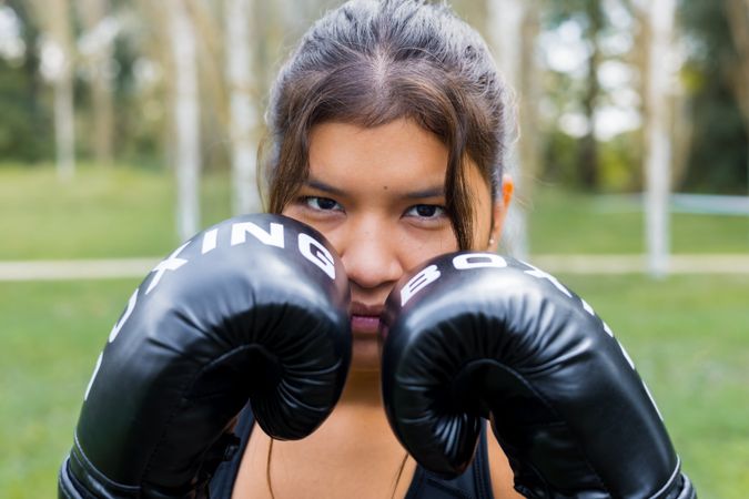 Boxer woman portrait wearing boxing gloves in a guard position