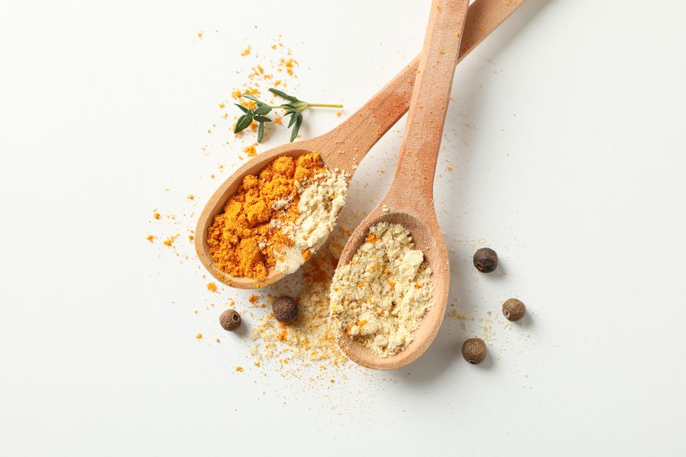 Top view of two wooden spoons full of spice
