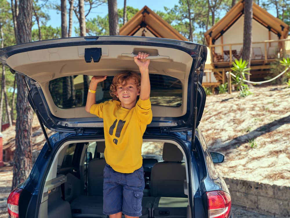 Boy playing in trunk near glamping campsite