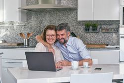 Mother and son having fun while watching video on laptop
