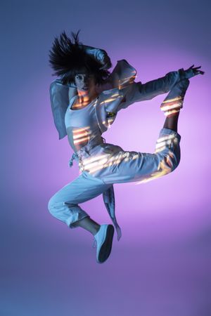 Energetic dancer jumping and looking at camera