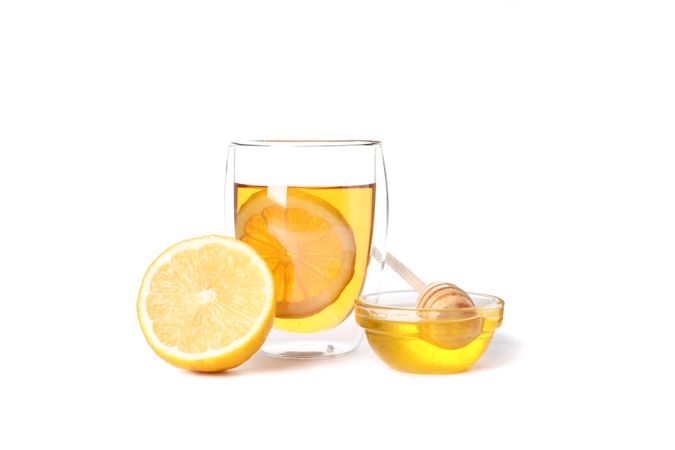 Glass of tea with lemon, honey and dipper isolated on plain background
