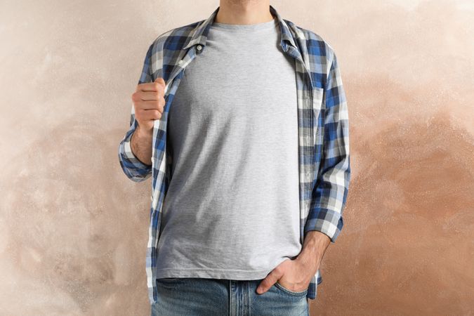 Men in grey t-shirt and checkered shirt against brown background, copy space