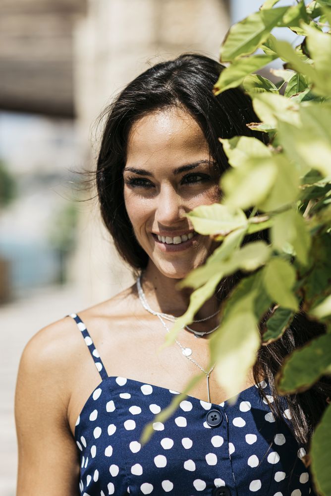 Closeup portrait of a beautiful hispanic woman in blue dress looking camera, vertical