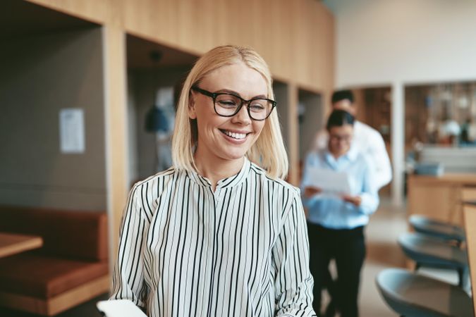 Smiling blonde business woman standing in office