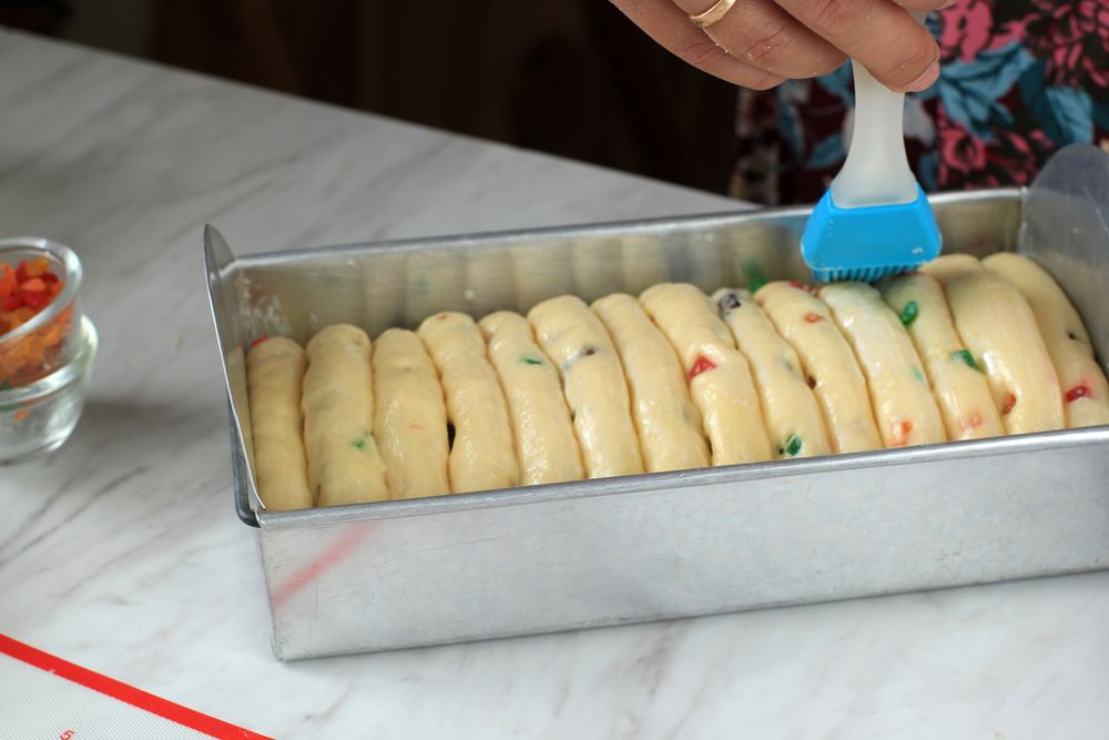 Female Hand Smearing Fresh Milk to Ready to Bake Bread
