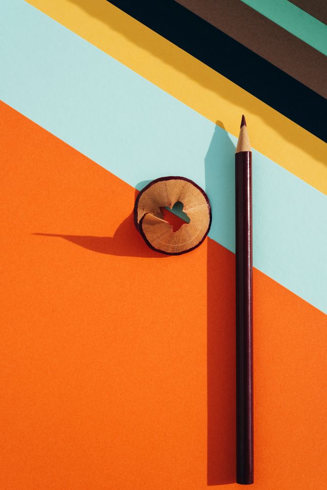 Pencil and shavings from sharpening, on colored striped papers