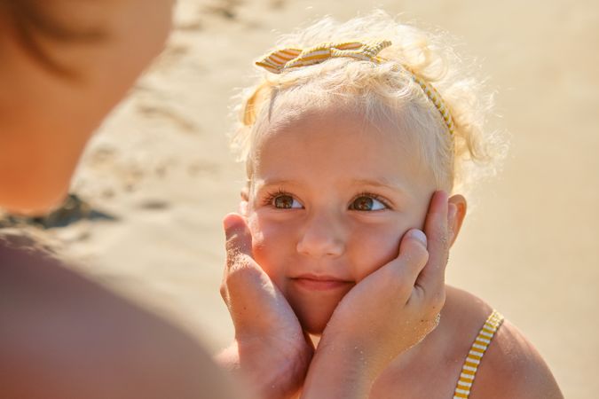 Cute little daughter looking at mother
